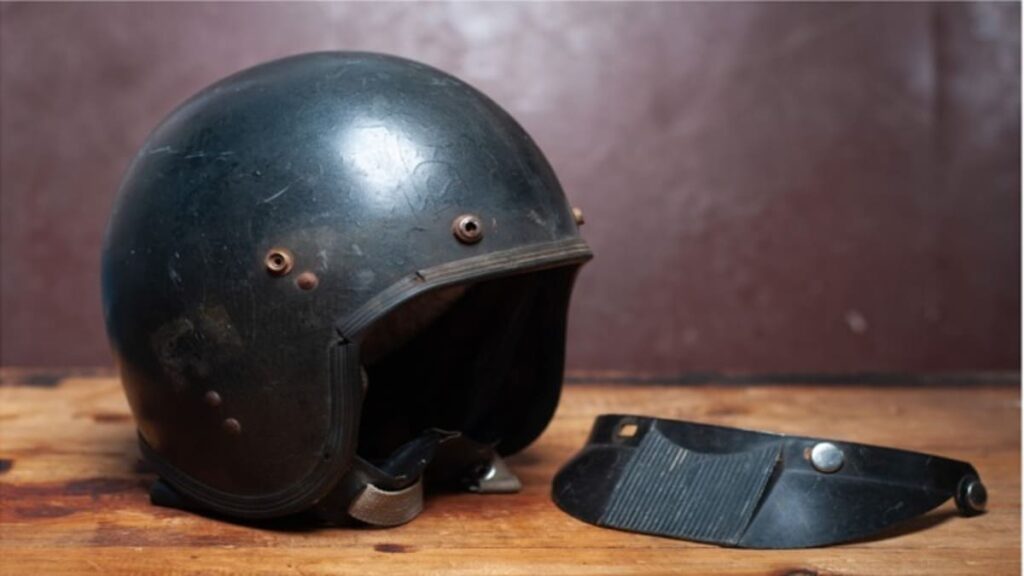 Capacete usado com viseira quebrada.