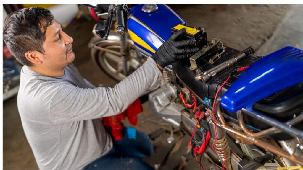 Profissional trocando a bateria da moto.